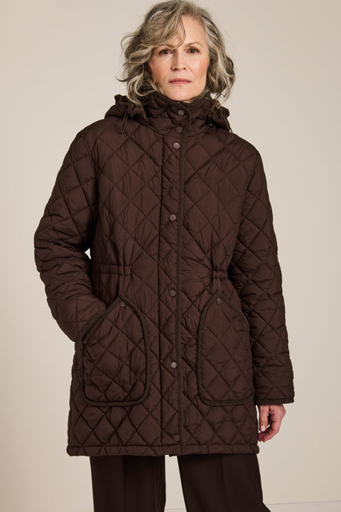 quilted hip length puffer jacket with a zip up enclosure and button up zip cover for women