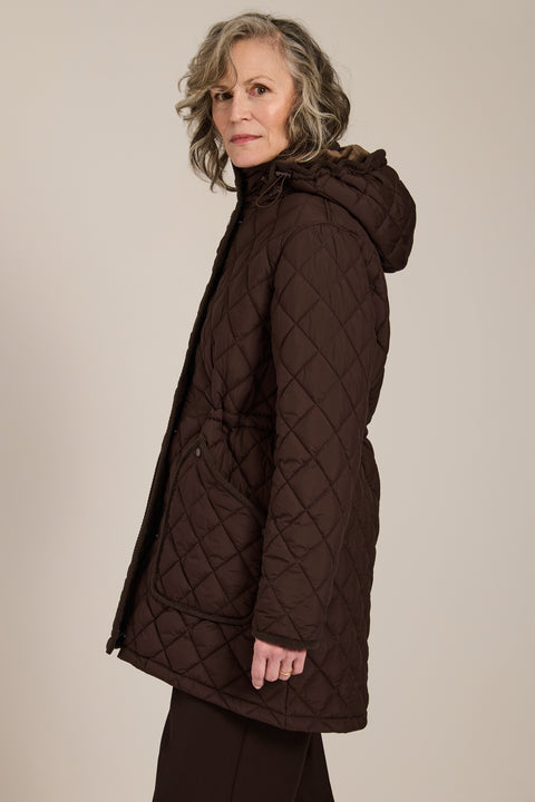quilted hip length puffer jacket with a zip up enclosure and button up zip cover for women