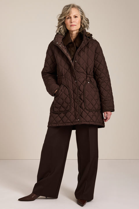 quilted hip length puffer jacket with a zip up enclosure and button up zip cover for women