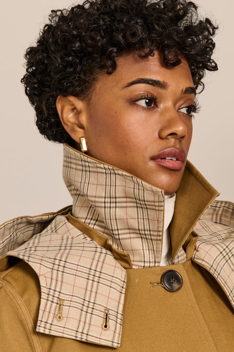 women's plaid-trim raincoat with a hood, stand collar, button-front closure, welt pockets and adjustable cuff tabs.