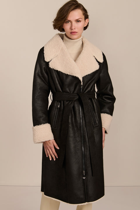 women's black faux shearling belted coat featuring ivory contrast trim, oversized notched collar, zip-front closure and zip pockets.