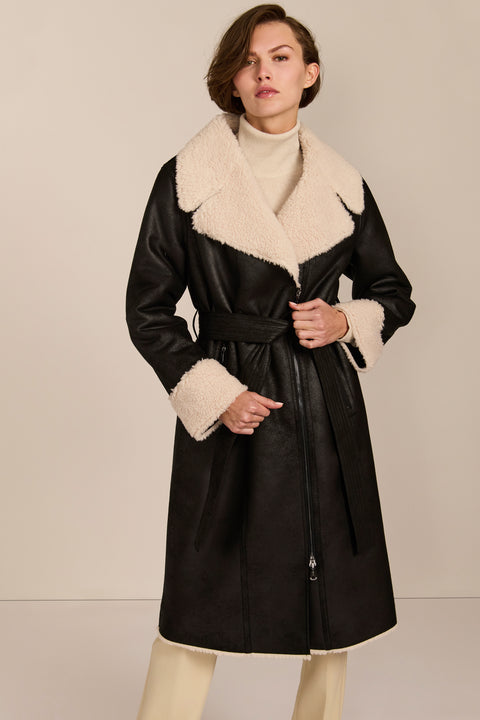 women's black faux shearling belted coat featuring ivory contrast trim, oversized notched collar, zip-front closure and zip pockets.