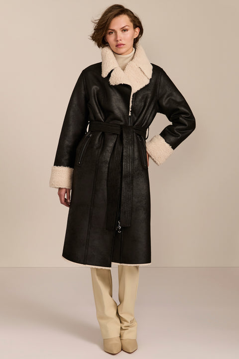 women's black faux shearling belted coat featuring ivory contrast trim, oversized notched collar, zip-front closure and zip pockets.