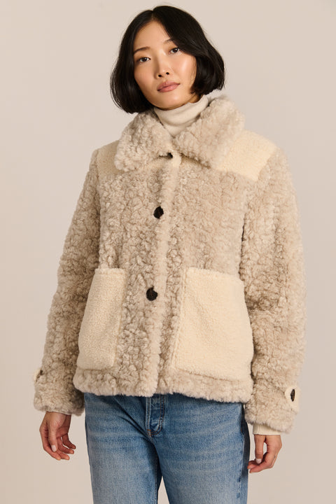 women's cream mixed-media teddy jacket with contrasting faux shearling textures, oversized patch pockets, button-front closure, and a plush stand collar.