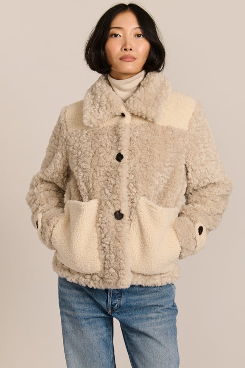 women's cream mixed-media teddy jacket with contrasting faux shearling textures, oversized patch pockets, button-front closure, and a plush stand collar.