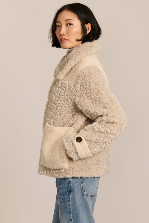 women's cream mixed-media teddy jacket with contrasting faux shearling textures, oversized patch pockets, button-front closure, and a plush stand collar.