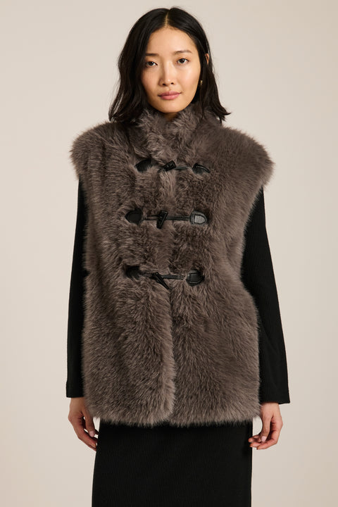 Women's faux fur vest with toggle closures, stand collar, and side pockets.