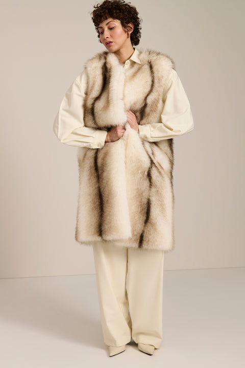 A lady wearing a long plush vest.