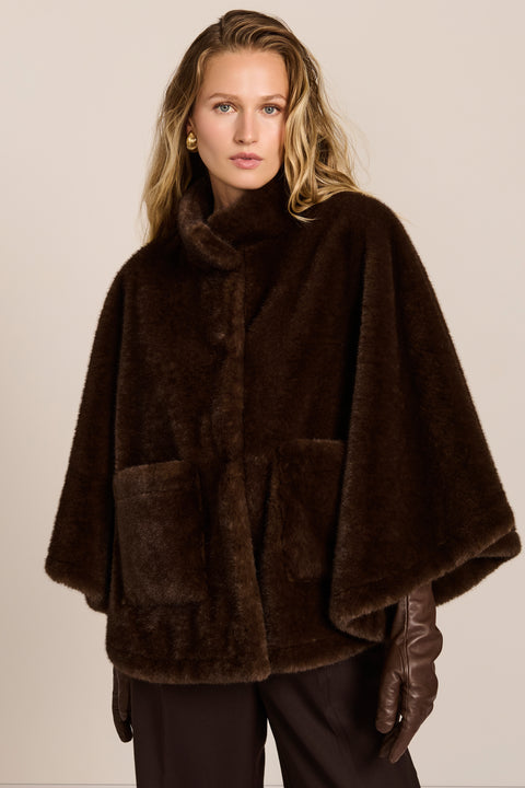women's Faux Fur Cape Jacket in chocolate brown with a stand collar, sweeping cape sleeves and oversized patch pockets.