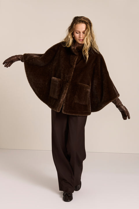 women's Faux Fur Cape Jacket in chocolate brown with a stand collar, sweeping cape sleeves and oversized patch pockets.