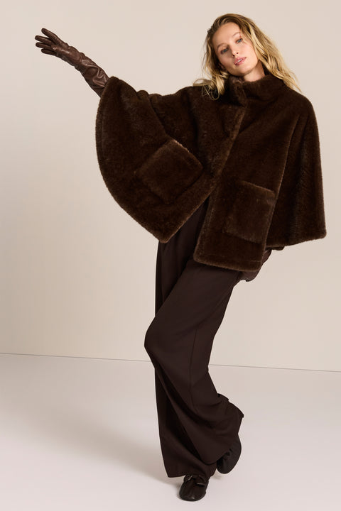 women's Faux Fur Cape Jacket in chocolate brown with a stand collar, sweeping cape sleeves and oversized patch pockets.