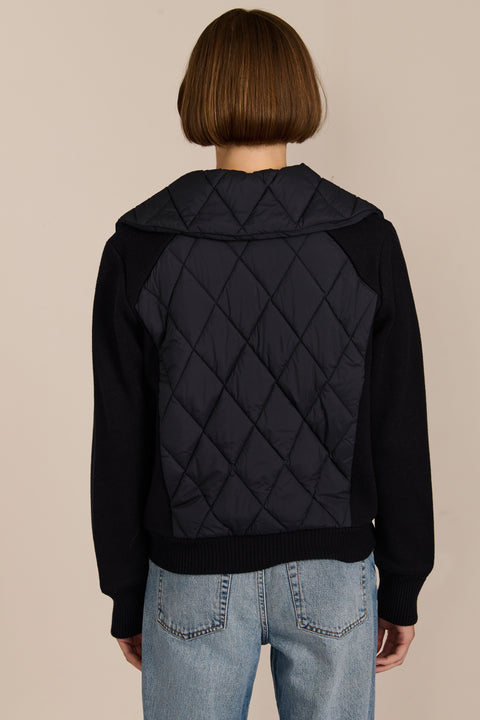 Women's quilted bomber jacket with knit sleeves.