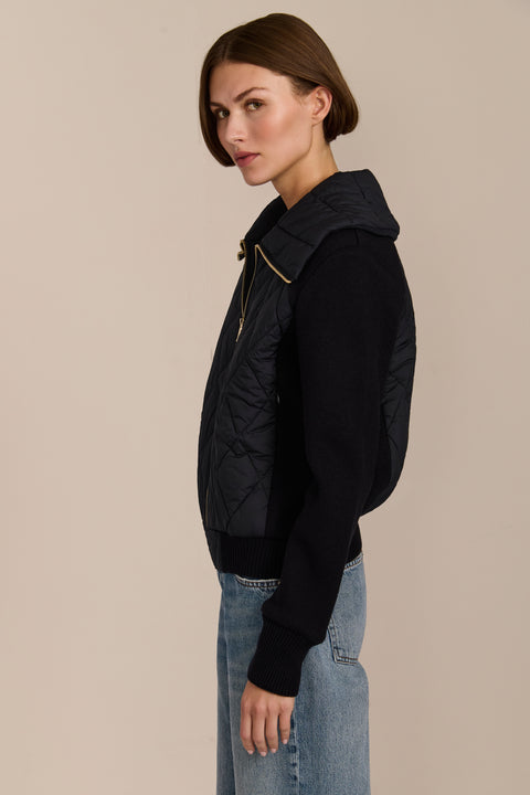 Women's quilted bomber jacket with knit sleeves.