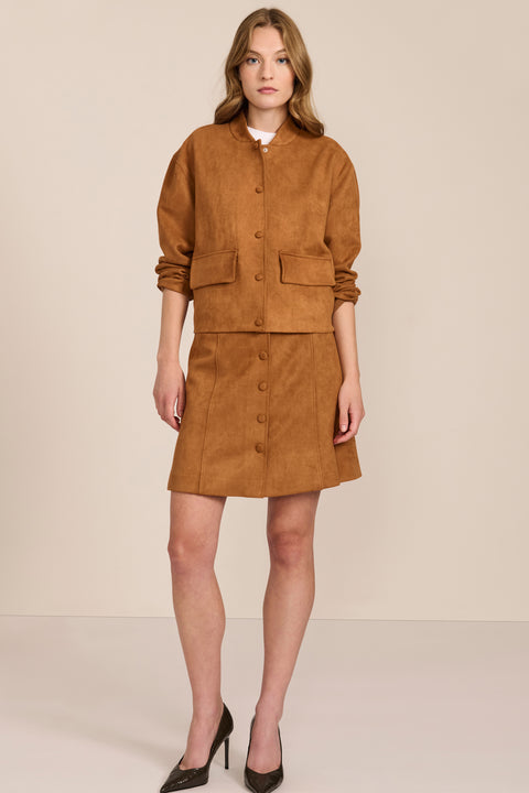 women's camel faux suede bomber jacket with a tonal snap front and flap pockets, styled with the coordinating mini skirt.