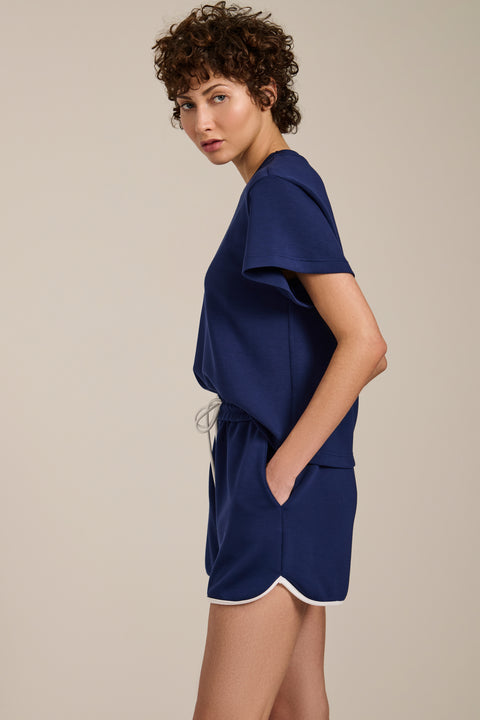Woman wearing cropped short sleeve tee in featherweight scuba with contrast trim detail and relaxed fit.