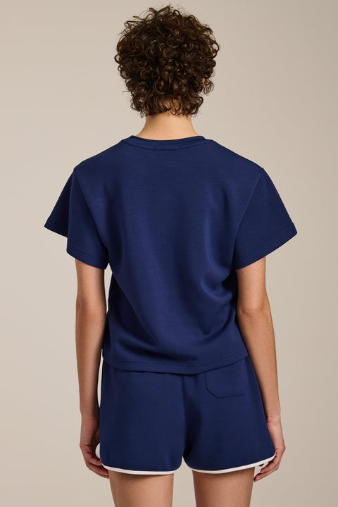Woman wearing cropped short sleeve tee in featherweight scuba with contrast trim detail and relaxed fit.