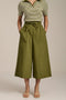 Woman wearing tech poplin wide leg culotte pants with elastic waist and patch pockets.