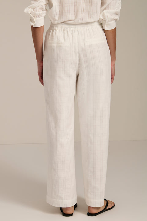 Woman wearing jacquard plaid relaxed pants with elastic drawstring waist and straight leg silhouette.