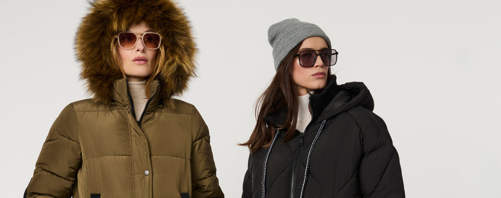 Two women in sunglasses and warm winter coats.