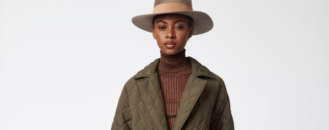A woman in a hat and walker coat.
