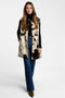 A model in a faux fur cow print vest for women with patch pockets and button closures.
