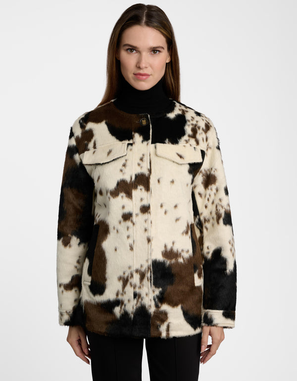 A model in a women's utility jacket with a cow print design against a white background.