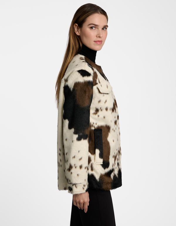 The profile of a female in a women's utility jacket with a cowprint design.