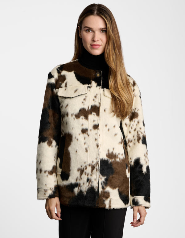 A woman wearing the Dakota Cow Print Utility Jacket for women.
