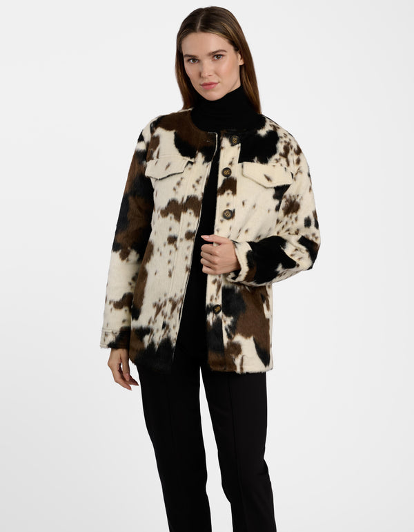 A lady wearing a cow jacket on a white background.