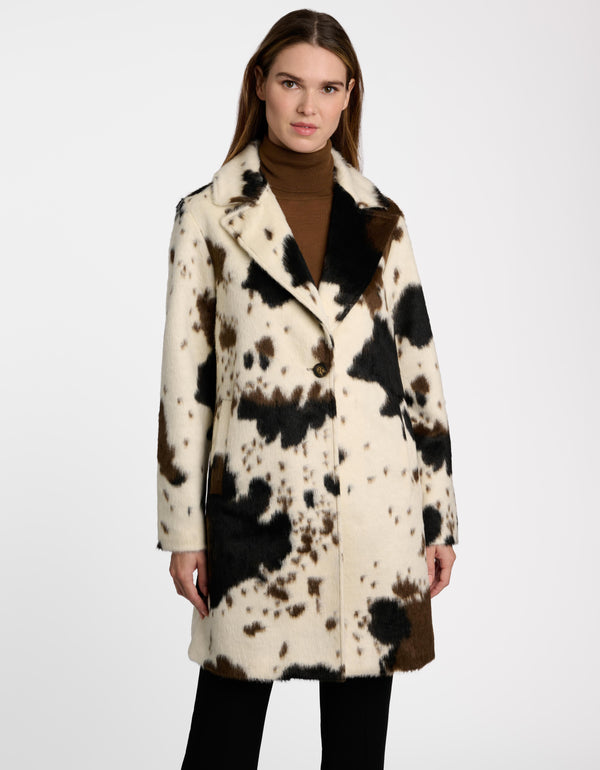 A woman wearing a cow print tailored coat from Bernardo Fashions.