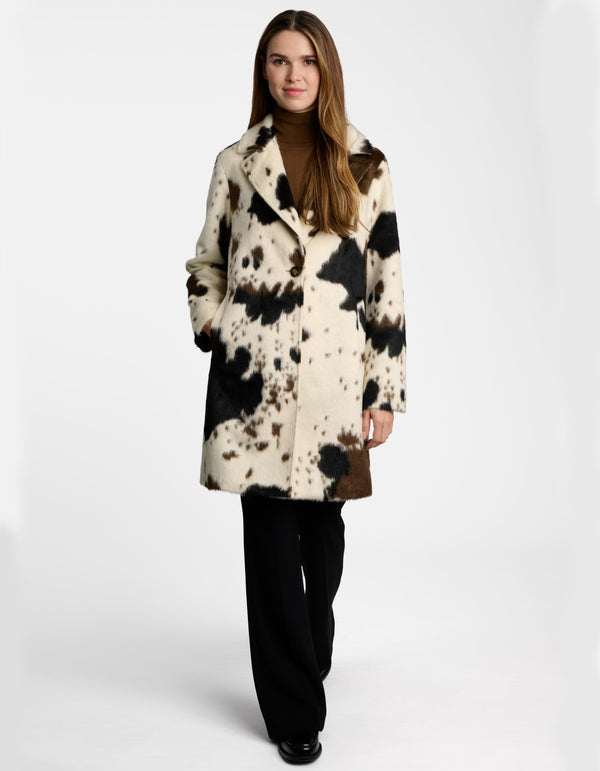 A model in a knee-length single-breasted coat with notch collar and polished silhouette.