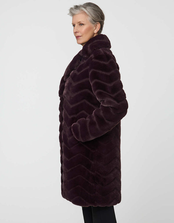 oversized vegan fur coat with tonal zigzag seams and angled hand pockets mid length design