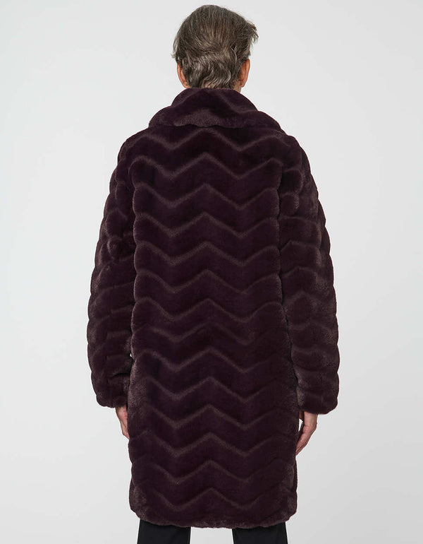 oversized vegan fur coat with tonal zigzag seams and angled hand pockets mid length design