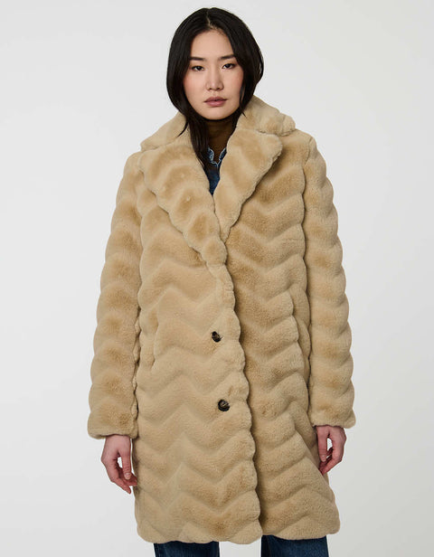 oversized tan vegan fur coat with tonal zigzag seams and angled hand pockets mid length design