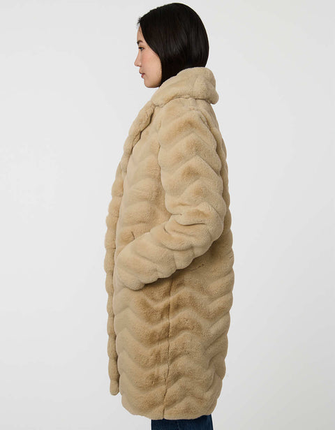 oversized tan vegan fur coat with tonal zigzag seams and angled hand pockets mid length design