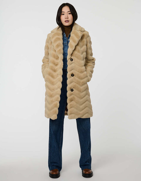 oversized tan vegan fur coat with tonal zigzag seams and angled hand pockets mid length design