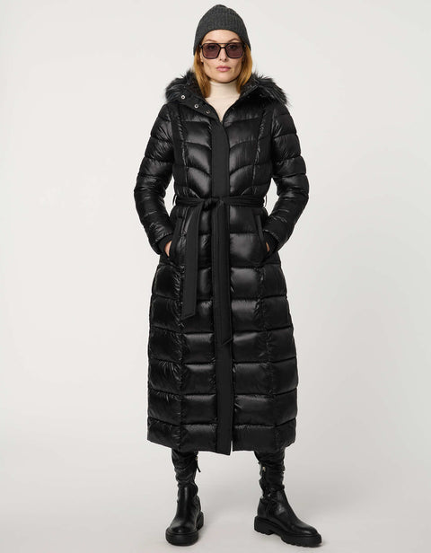 Person wearing a long black puffer coat with a hood on a white background