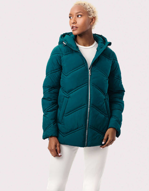 Shop Bernardo womens puffer jackets like this sustainable style with Ecoplume insulation Chevron stitching and a high low hem define the design