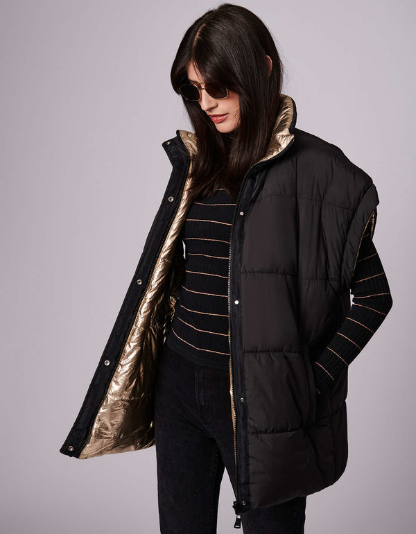 The women's reversible puffer vest has an oversized fit and sustainable style, made from 100% recycled materials.