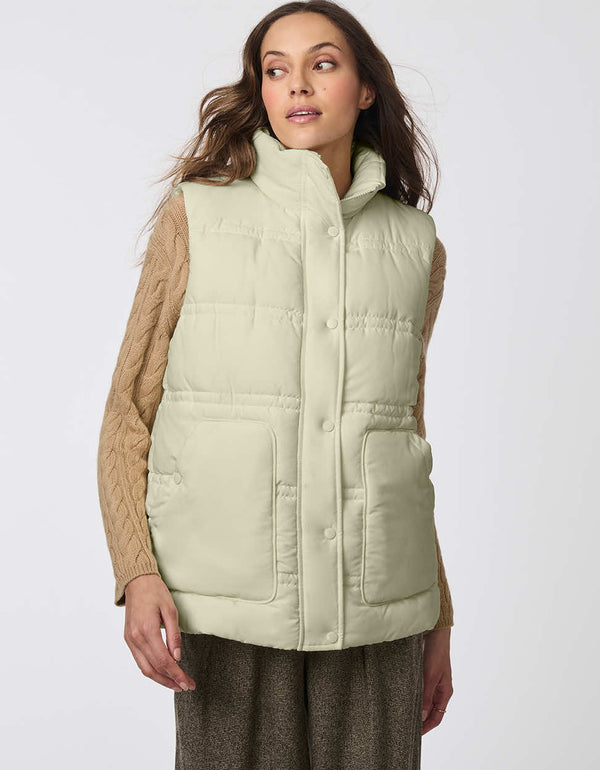 light green cozy puffer vest with sustainable insulation to keep the modern woman warm for urban adventures