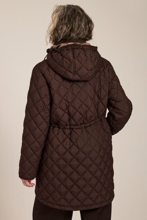 quilted hip length puffer jacket with a zip up enclosure and button up zip cover for women