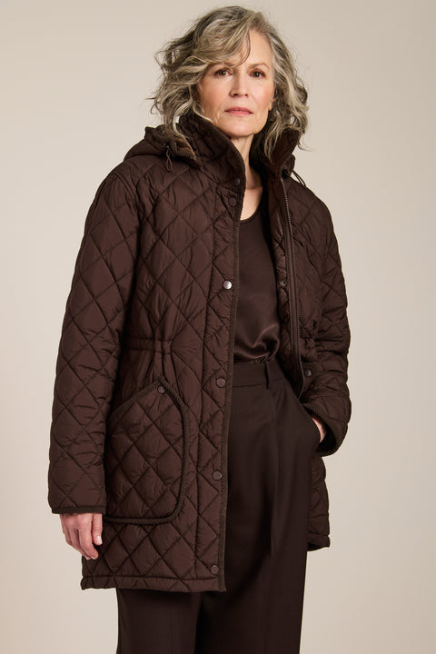 quilted hip length puffer jacket with a zip up enclosure and button up zip cover for women
