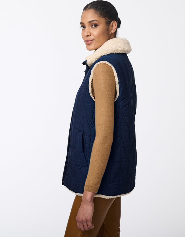 well insulated reversible vest for women with a sherpa lined side and navy blue quilted pocketed side