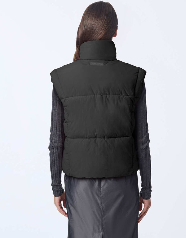 Women's sustainable puffer vest made with recycled materials. Hip-length with zipper and snap closure