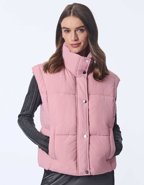 Women's sustainable puffer vest made with recycled materials. Hip-length with zipper and snap closure