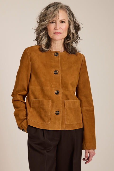 Collarless genuine suede jacket with oversized patch pockets, button-front closure and tailored silhouette.