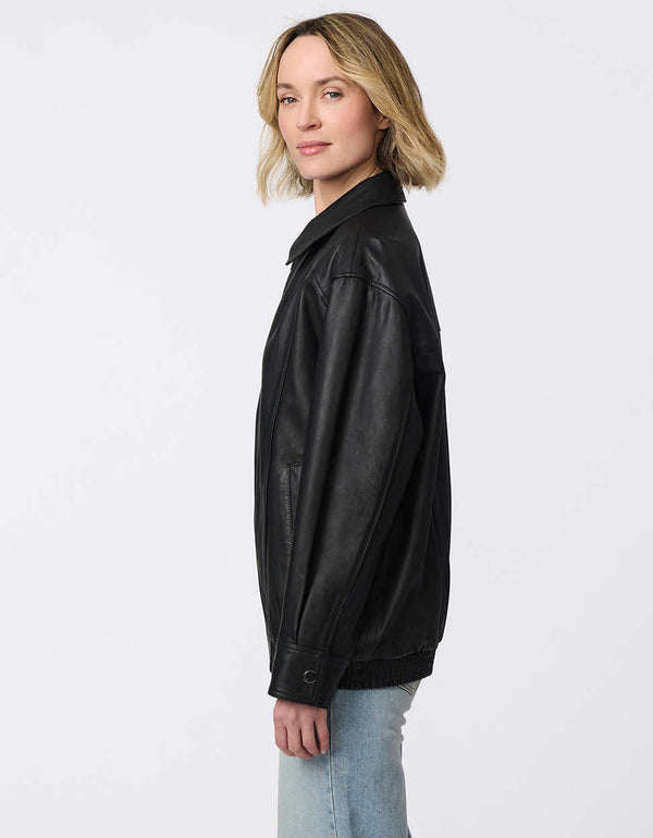 Minimalist leather jacket with sleek zip closure, elastic bottom hem, and streamlined silhouette. Effortlessly cool and versatile for day-to-night looks.