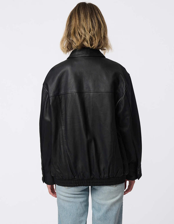 Minimalist leather jacket with sleek zip closure, elastic bottom hem, and streamlined silhouette. Effortlessly cool and versatile for day-to-night looks.