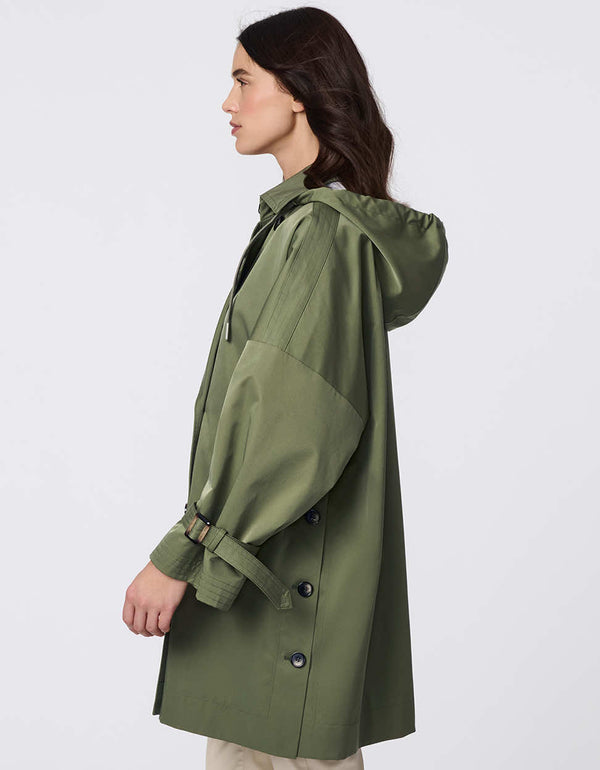 Oversized double-breasted trench with adjustable cuff straps, drawstring hood, and side button accents. Effortless, sophisticated layering piece.