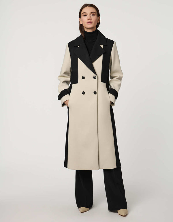 A woman wearing a black and white colorblock coat.